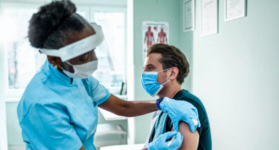 Hombre es vacunado por enfermera, ilustra nota de EEUU abre vacunación contra el coronavirus a todos los mayores de 16 años