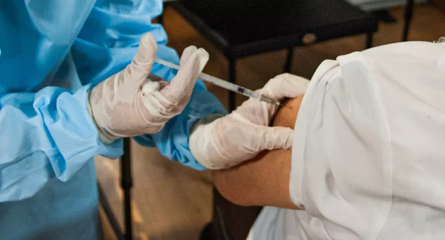 Enfermera vacunando a una persona ilustra nota sobre casos de aplicación de vacunas contra la COVID-19 a personas registradas como muertas