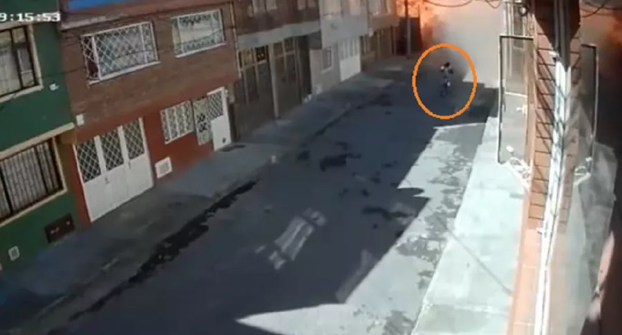 Imagen del momento en que ciclista cruza por el sitio de la explosión en Engativá, Bogotá, en donde una persona murió