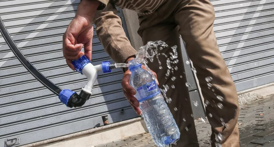Imagen de hombre llenando botella con agua ilustra artículo Bloqueos por paro nacional afectaría servicio de agua en Bogotá 