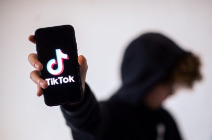 Joven mostrando 'app' de TikTok ilustra nota sobre influencer que murió grabando un video para esa red social