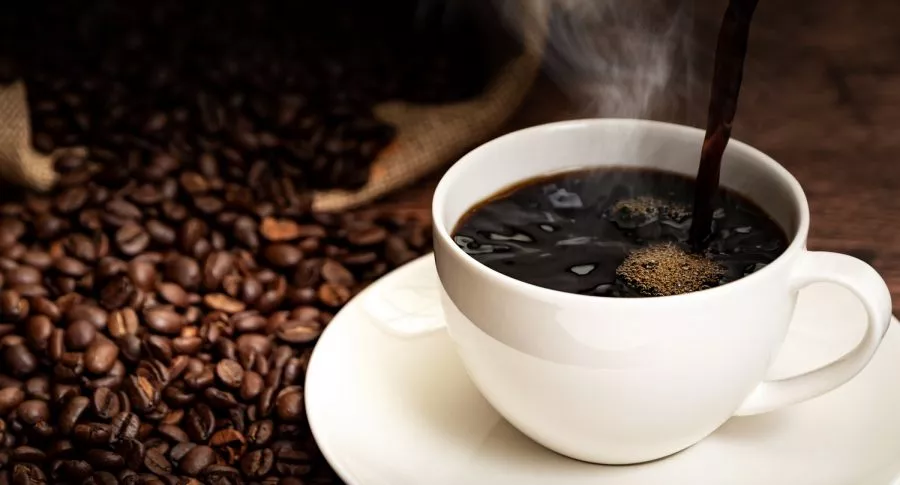 Taza y granos de café ilustran nota sobre la caída de las exportaciones de ese producto, por los bloqueos