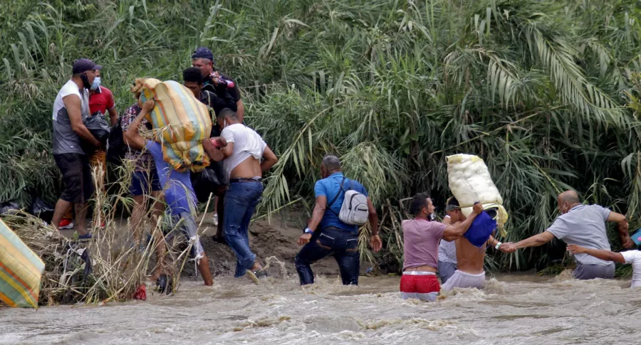 Migrantes venezolanos cruzan el río Táchira a su ingreso a Colombia