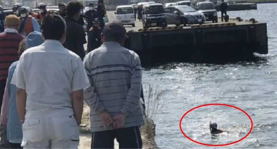 Captura de pantalla de foto viral de momento en que rescatista se lanza al mar para salvar a mujer, pero era una muñeca inflable