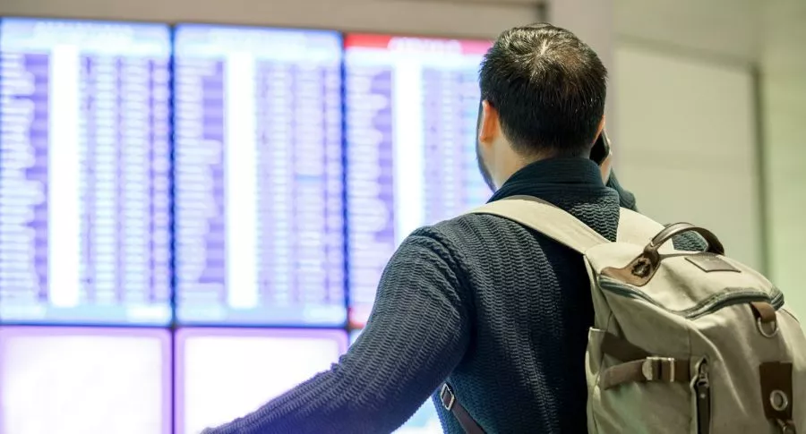 Hombre mirando hora de vuelos ilustra nota sobre cómo viajar a EE. UU. si se es emprendedor