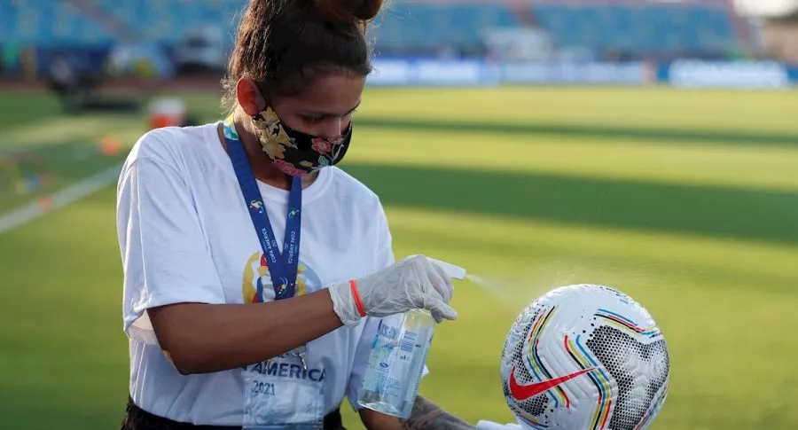 Joven limpia balón de Copa América, ilustra nota de ya son 166 casos positivos de coronavirus en el torneo