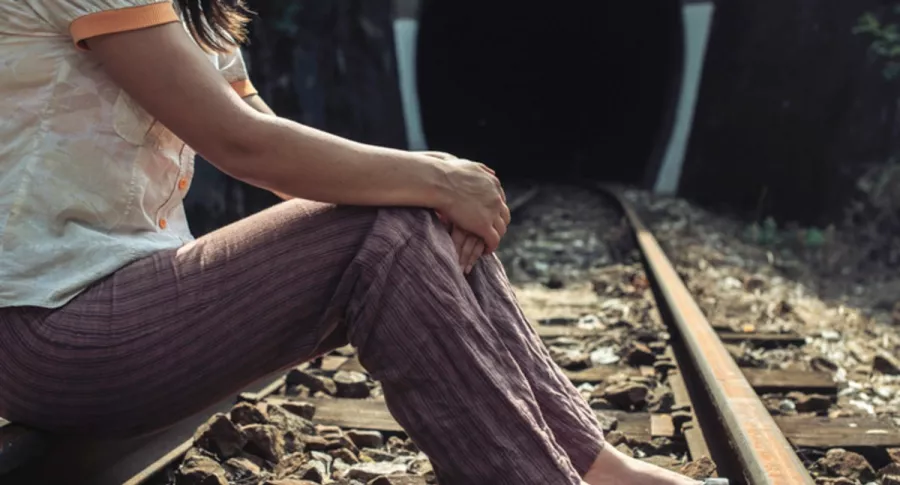Mujer sentada sobre vías de un tren, ilustra nota de Mujer muere arrollada por tren luego de tropezar por tomarse una selfie
