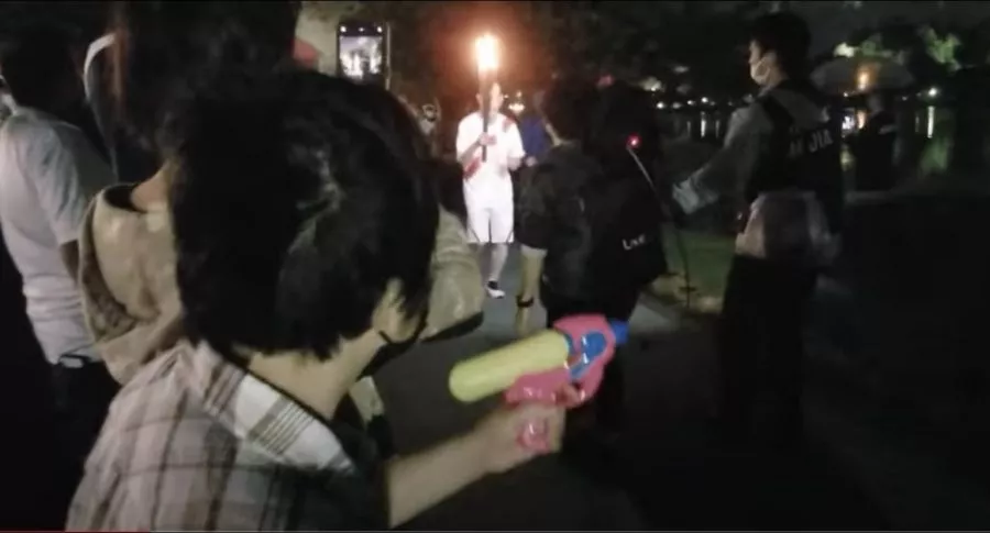 Imagen de la mujer que intentó apagar la llama olímpica, con una pistola de agua, en protesta por los Juegos Olímpicos en Tokio