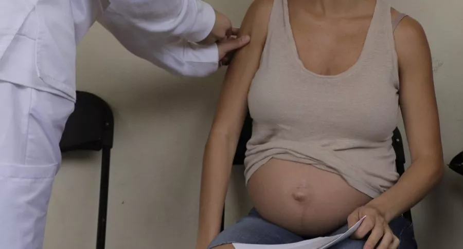 Mujer embarazada siendo vacunada ilustra nota de problemas en Bogotá para vacunar a mujeres embarazadas