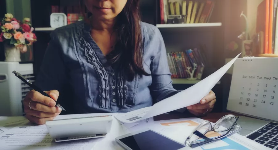 Foto persona revisando documentos, en nota de Cuándo declarar renta en 2021: calendario de declaración de renta y cómo hacerla.