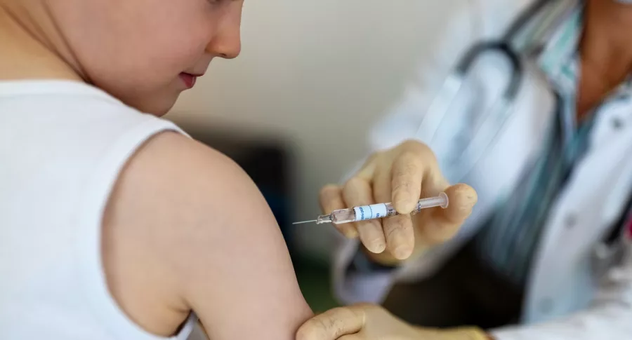 Imagen de un niño vacunándose, que ilustra información sobre ensayos de Sinovac en Colombia