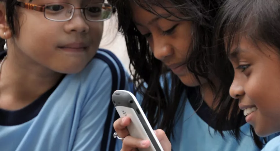 Imagen de niñas observando un celular ilustra artículo YouTube estrenan funciones para evitar que menores accedan a contenido adulto