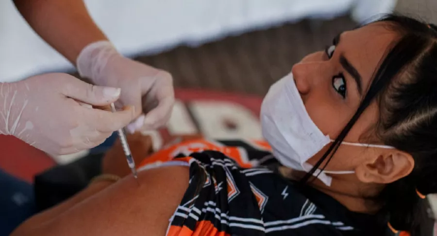 Una joven recibe la vacuna para el COVID-19 en Colombia, donde personas de 220 a 24 años comenzarán a ser inmunizadas.