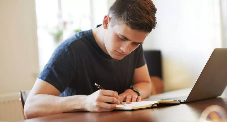Foto de joven escribiendo, en nota de cifras de personas que no estudian ni trabajan.