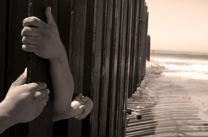Foto de manos detrás de una cerca, en nota de madre e hija que murieron en frontera de México y Estados Unidos.