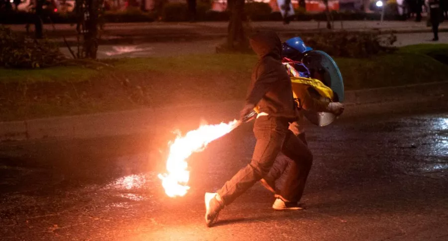 Foto de persona en protestas en Bogotá, en nota de policías quemados en protestas.