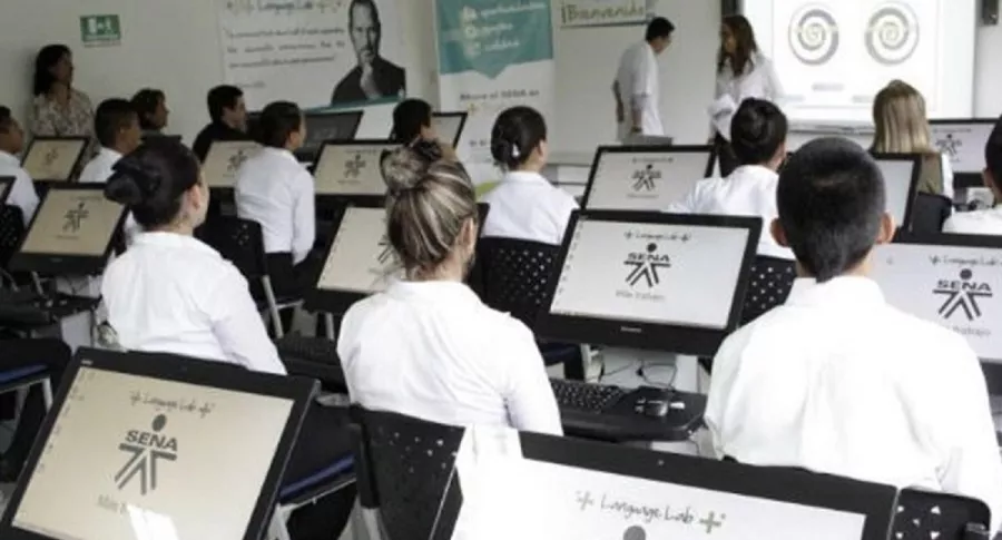 Grupo de estudiantes con computadores para ilustrar nota de cursos virtuales del Sena.
