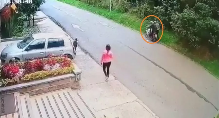 Imagen de dos ladrones en moto cuando atacan a una mujer por robarla, en Chapinero