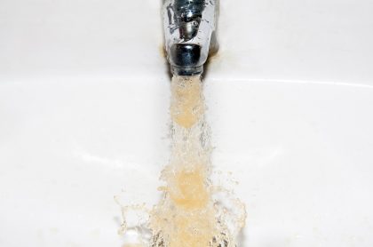 Llave con chorro de agua amarilla ilustra explicación del Acueducto de por qué el agua de Bogotá cambió de color.
