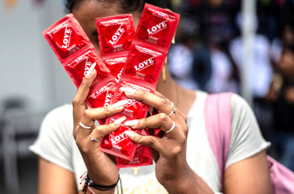 Regalos más buscados en día de Amor y Amistad; condones, entre los más vendidos. Imagen de referencia de una mujer con preservativos.