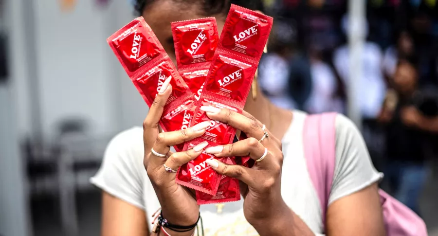Regalos más buscados en día de Amor y Amistad; condones, entre los más vendidos. Imagen de referencia de una mujer con preservativos.