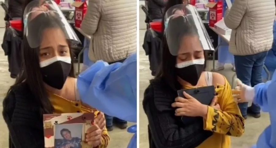 Mujer que se vacunó abrazando la foto de su mamá, que murió por COVID-19