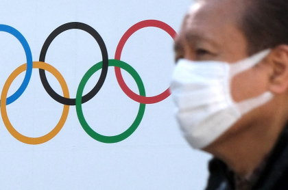 Wuhan, China, pide sede de Juegos Olímpicos. Logo de las justas y un hombre con tapabocas.