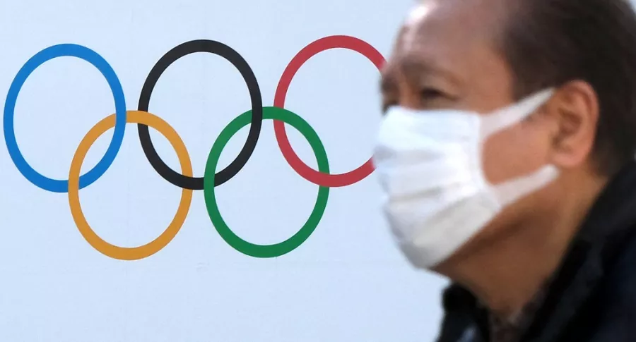 Wuhan, China, pide sede de Juegos Olímpicos. Logo de las justas y un hombre con tapabocas.