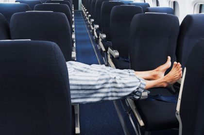 Hombre acostado en avión, ilustra nota de Hombre disfrutó de vuelo internacional al ser único pasajero dentro de avión
