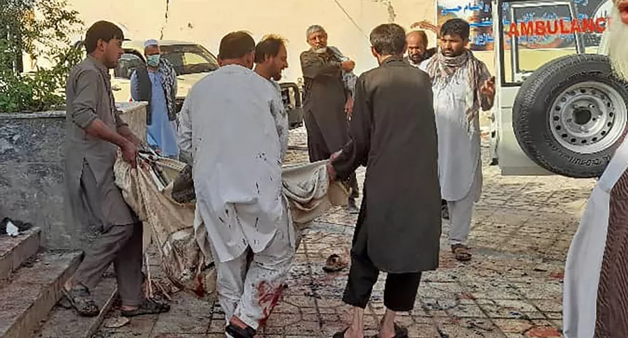 Varias personas recogen cuerpos en el lugar de la explosión en Kunduz