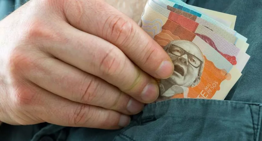 Foto de persona con dinero colombiano, en nota de término 'finfluencer' para referirse a personas que dan consejos financieros en redes sociales.