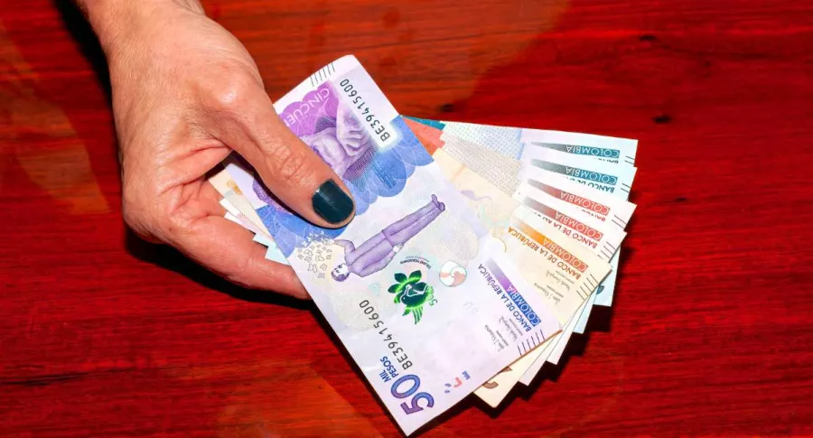 Foto de persona con dinero colombiano, en nota de Colpensiones y qué beneficios tiene frente a fondos de pensiones privados.