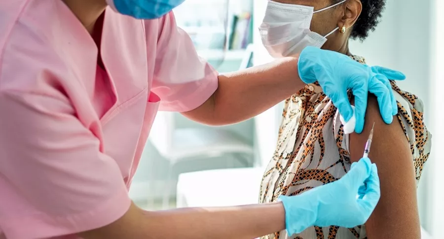 Mujer recibiendo la vacuna, para ilustrar posibilidad de vacuna obligatoria en Colombia y la negativa de la OMS