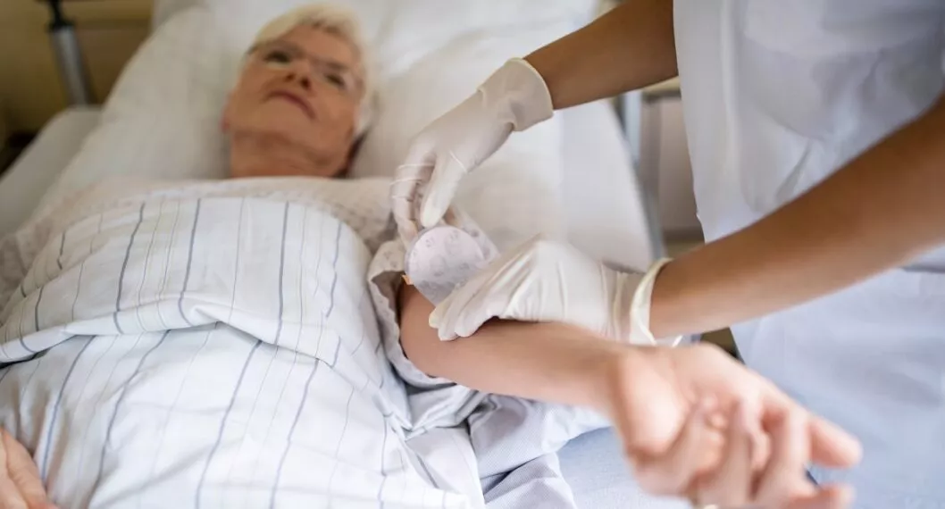 Mujer anciana atendida por una enfermera, por casos de coronavirus del 8 de diciembre.