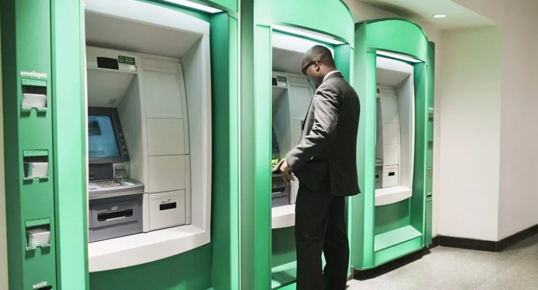 Persona retirando dinero de un cajero automático, apropósito de lo que puede pasar si la máquina no entrega el monto solicitado    