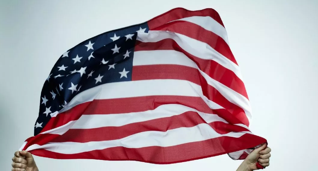 Persona con la bandera de Estados Unidos en las manos a propósito de la oferta educativa que lanzó la Embajada de EE. UU. en Colombia 