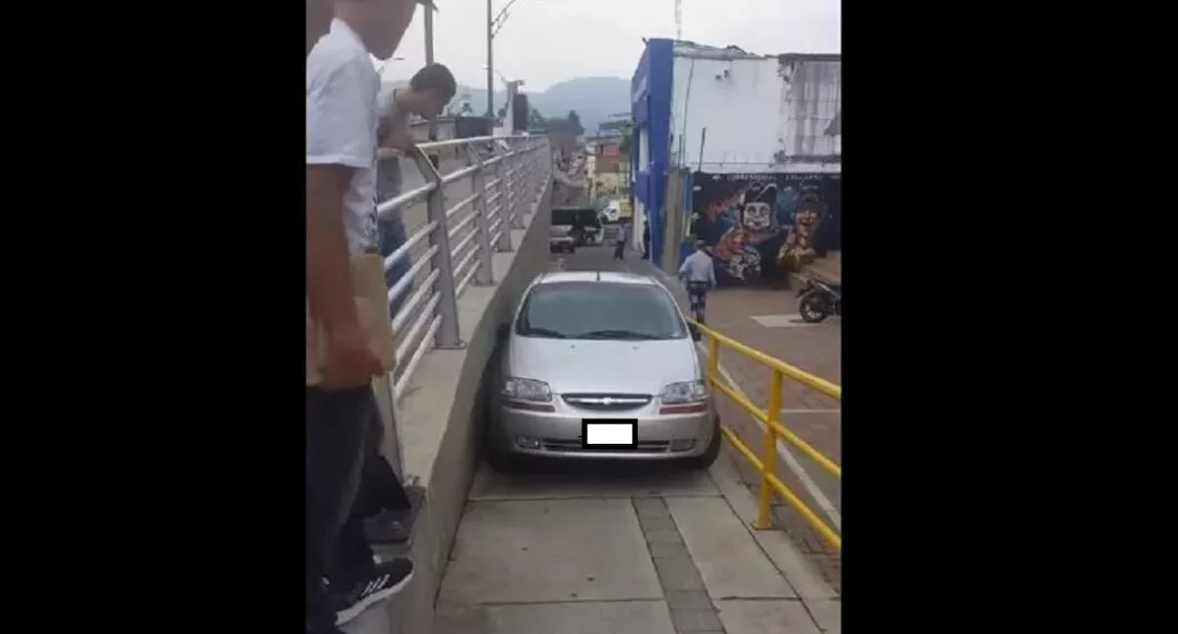 Imagen del carro atascado al intentar cruzar un puente peatonal en Pereira 