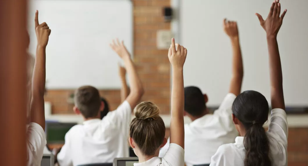 Niños alzando la mano ilustran nota sobre los mejores colegios de Colombia, según el Icfes