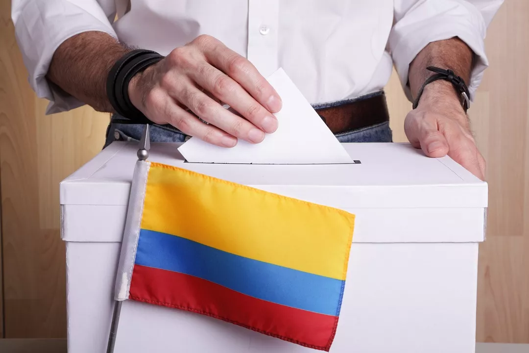 Hombre insertando voto ilustra nota sobre cómo los colombianos que están en Venezuela pueden votar