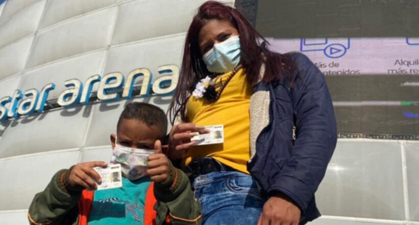Mujer venezolana con su hijo muestran su Permiso de Protección Temporal