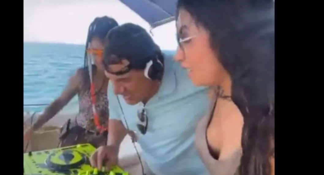 Poncho Zuleta en un yate bailando con mujeres y haciendo de DJ. 