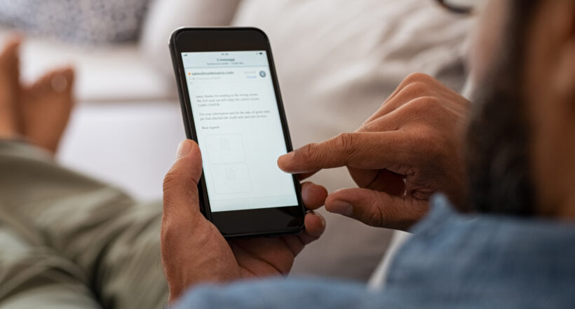 Hombre mirando el celular ilustra nota sobre cómo revisar puntaje en Datacrédito gratis y desde el celular