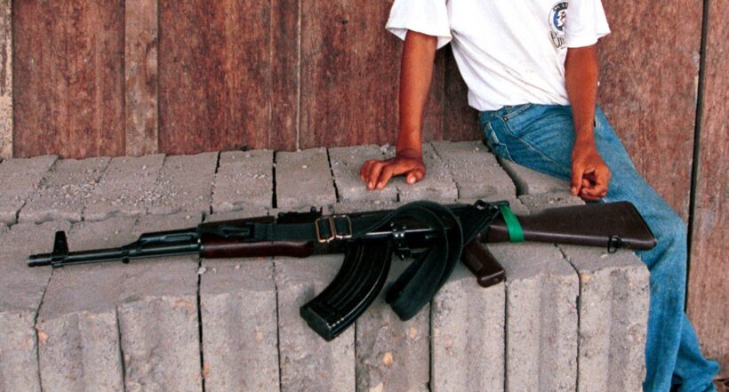 Un menor junto a un arma larga en Colombia.