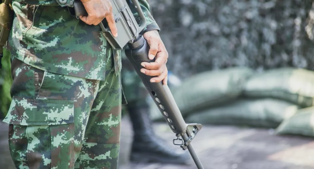soldier with Colt M16 gun stand guard to security military camp