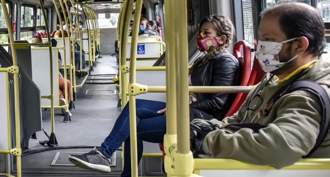 Personas con tapabocas en Bogotá ilustran nota sobre si se podrá utilizar Transmilenio sin la máscara