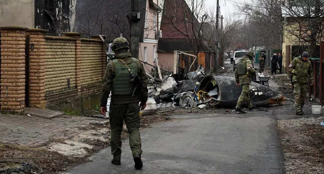 Militares ucranianos trabajan junto a los restos de un avión no identificado que se estrelló contra una casa privada en una zona residencial de Kiev el 25 de febrero de 2022. 