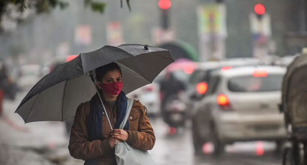 Mujer con paraguas ilustra artículo Ideam anuncia que el país apenas entra a temporada de lluvias