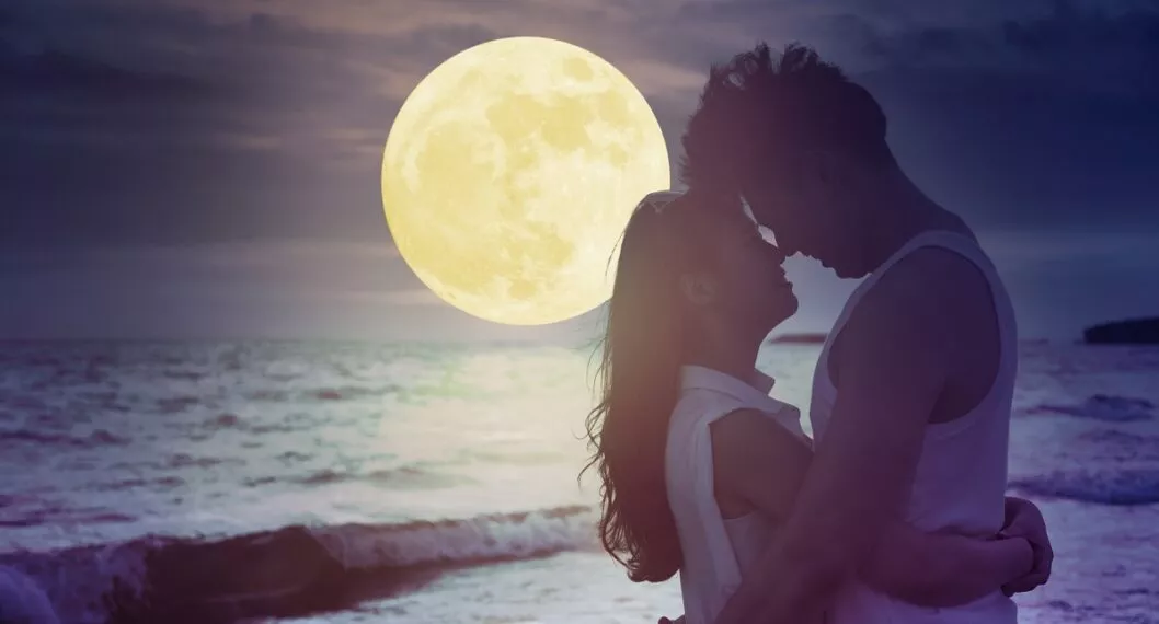 young couple kissing on beach and watching the moon.Celebrate Mid autumn festival