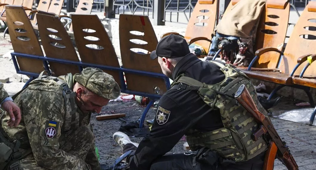 Militares ucranianos auxilian a una persona en la estación de tren