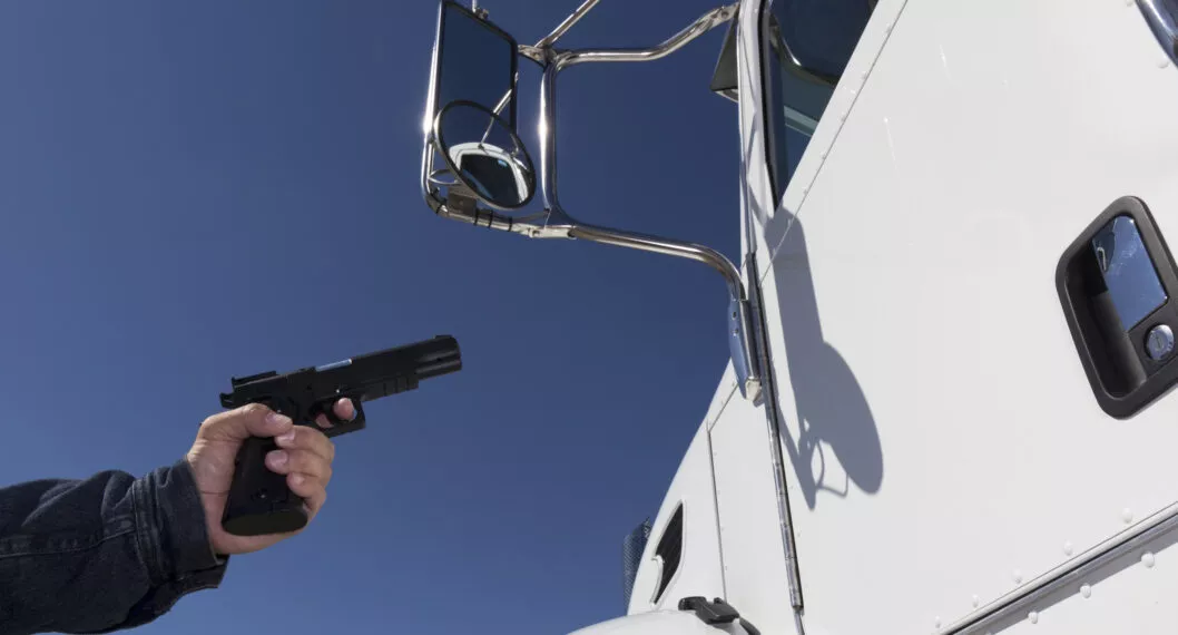 An image from the transportation industry of a truck driver being held up at gunpoint.